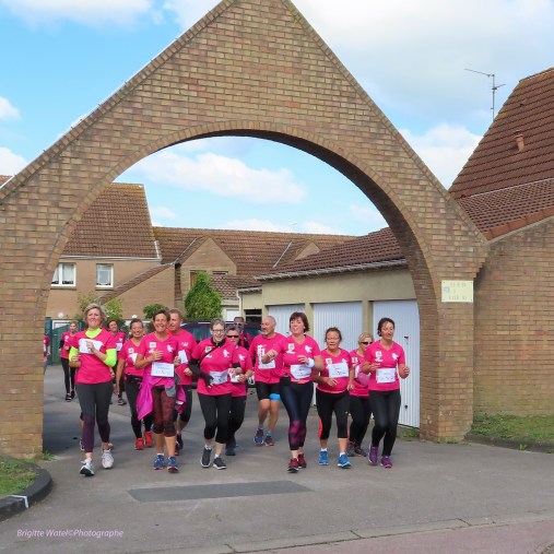 Des bénévoles en maillots roses courent ensemble lors du défi sportif Triathlon Rose.
